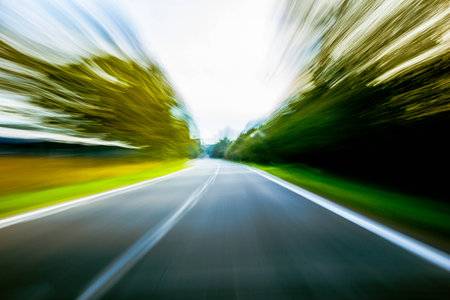 A car speeding down the road that is blurred.の写真素材
