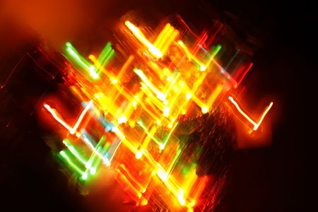 An abstract colorful background of lit Christmas ornaments in motion.
