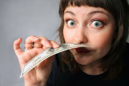 Woman with hand of money, looking fury with herselfの写真素材