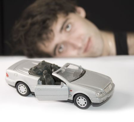 Young Man with silver toy car. Focus on car. の写真素材