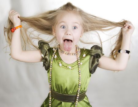 Head and hands shot of little girl sticking out her tongue. の写真素材
