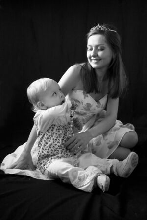 Baby and happy mother isolated on blackの写真素材