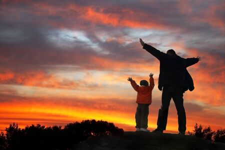 Expressing Father and Son stand on the stone,  Arms Raised to heaven. の写真素材