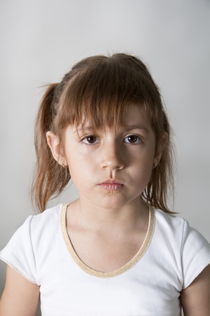 Sadness little girl. White grey.の写真素材