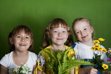 Three girls of the girlfriend - the cheerful company. Green background