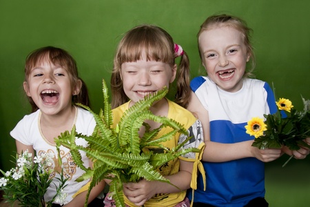 Three girls of the girlfriend - the cheerful company. Green backgroundの写真素材