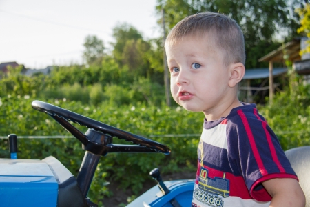 Boy at a wheel of a small tractorの写真素材