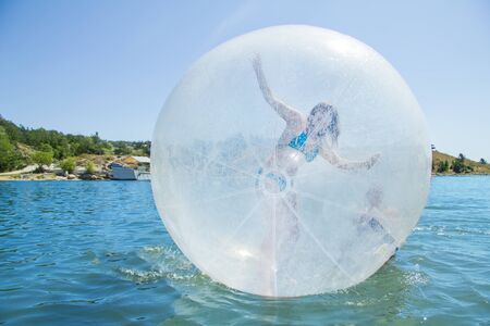 Joyful children in a balloon floating on water.の写真素材