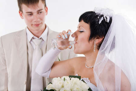 The groom and the bride drink water. White isolated.の写真素材