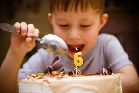The boy looks at the birthday cake