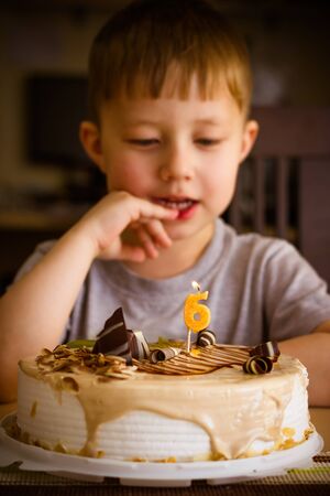 The boy looks at the birthday cakeの写真素材