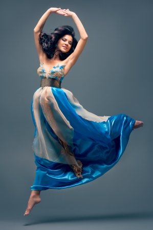 beautiful girl floating in mid-air, blue silk dressの写真素材