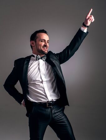 Cool man in a suit with a cigar, gun and glass with alcoholic beverageの写真素材