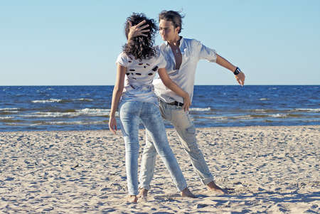 young couple dancing on a background of seaの写真素材