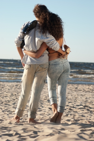 A young couple on the background of the sea at sunset, enjoying the weatherの写真素材