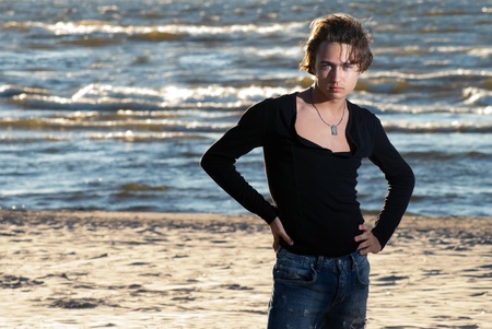 a young guy on the background of the sunset seaの写真素材