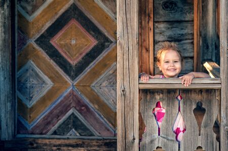 Young girl near an old wooden houseの写真素材