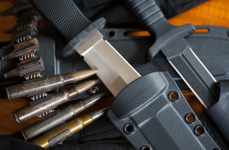 Military knives and scabbard on the wooden background