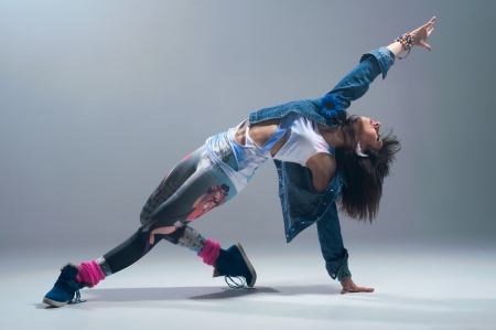 Woman in pink grunge clothes dancing in a studio 