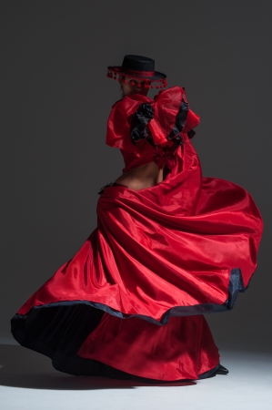 Woman in beautifull red dress dancing in a studioの写真素材