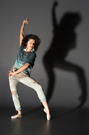Sexy woman dancing in pointes modern dance. Photo in a studio. Hands upの写真素材