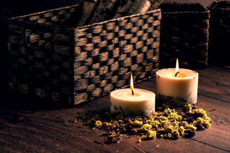 Dry yellow flowers petals and candles with wicker baskets background vilge styleの写真素材