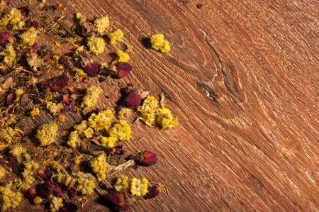 Dry yellow flowers petals on wooden backgroundの写真素材