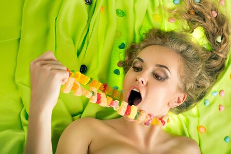 Beautiful woman eating tasty candiesの写真素材