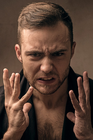 Shocked young man on dark background