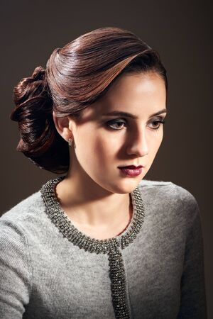 Young beautiful woman with fashion hairstyle posing in the studio