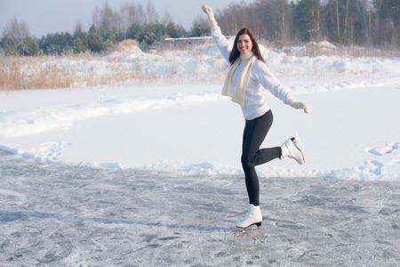 young Figure skating woman at the frozen lake in the winterの写真素材