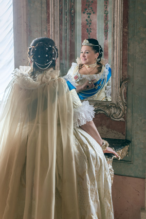 Historical cosplay. Beautiful woman in the similitude of Catherine the Great, empress of Russia ancient dress in the palaceの写真素材