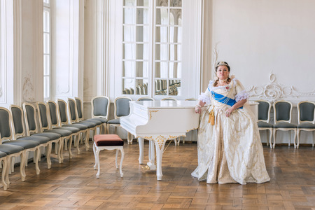 Historical cosplay. Beautiful woman in the similitude of Catherine the Great, empress of Russia ancient dress in the palaceの写真素材