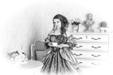 Pretty woman in luxury vintage dress standing in bright roomの写真素材