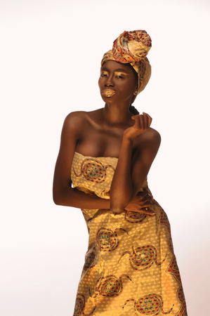 Portrait of cheerful african woman with creative gold makeâup and turbanの写真素材