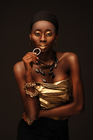 African beautiful woman in gangsta rapper style with gold makeâup and jewelryの写真素材