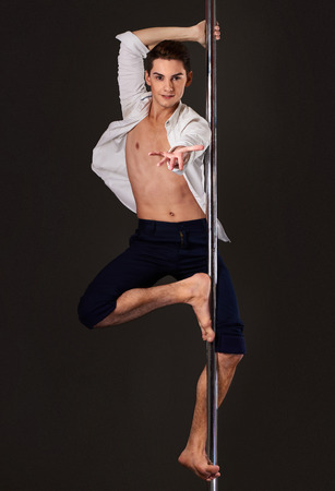 Male pole dancer with stage look posing for fashion magazine coverの写真素材
