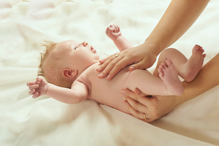 blond babe lies on the bed and receives a tummy massageの写真素材