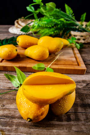 There are fresh mangoes and cut mango pulp on the board