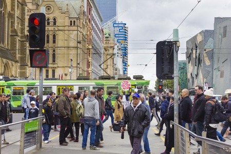 Melbourne, Australia - July 25, 2015: View of a protester holding stop racism now placards while people crossed the street neglecting him outside the Flinders Street Station in Melbourne.のeditorial素材