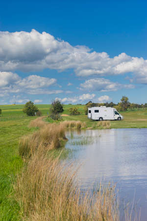 Motorhome in meadow in blue skyの写真素材