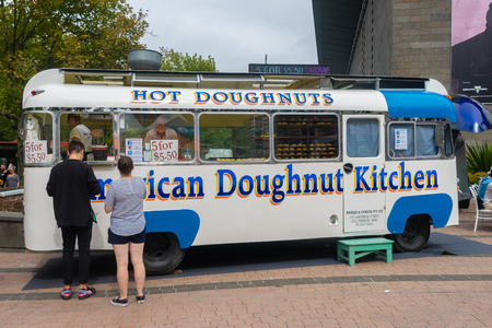 Melbourne, Australia - March 5, 2016: People buying doughnuts in front of a food truck selling American doughnuts in the street in Melbourne. Food trucks represent a new generation of dining.のeditorial素材