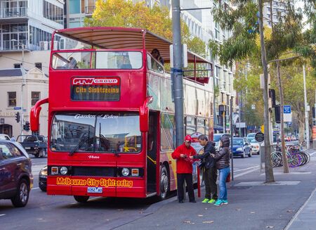 Melbourne, Australia - April 30, 2015: Two tourists asking a bus driver for information outside a sightseeing open top double decker bus stop in the city of Melbourne.のeditorial素材