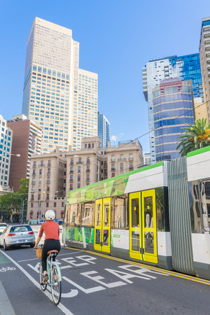 Melbourne, Australia - May 1, 2016: View of cyclist, cars and tram  with modern and historical buildings as background in Melbourne during daytime.のeditorial素材