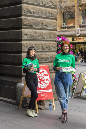 Melbourne, Australia - July 2, 2016: View of two volunteers from the Australian Greens party waiting to hand out pamphlets at Melbourne Town Hall to voters.のeditorial素材