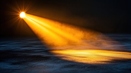Radiant gold spotlight shining from above onto a black velvet stage, casting smooth golden shadowsの素材