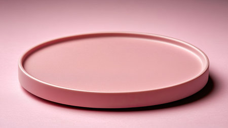 Minimalist product display platform in soft pastel pink background with subtle shadows and clean surfaceの素材