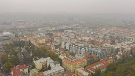 Prague red roofs and dozen spires of historical Old Town of Prague. Cityscape of Prague on a misty and foggy day. Red rooftops, spires and the old city in the background. Prague, Praha, Czechia.の写真素材