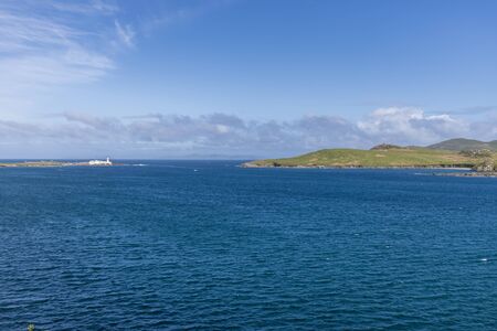 Beautiful view of Valentia Island Lighthouse at Cromwell Point. Locations worth visiting on the Wild Atlantic Way. Scenic Irish countyside on sunny summer day, County Kerry, Ireland.の写真素材