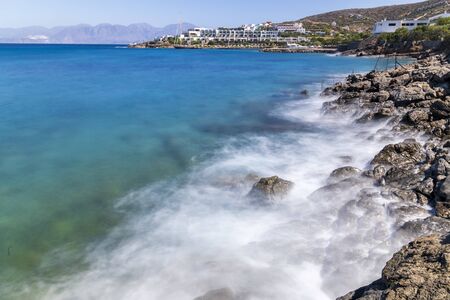 Waves hitting the rocks during hot summer day in Greeceの写真素材
